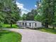 Single-story home on large lot, features include gravel driveway and cozy front porch at 10379 Turnplow Dr, Davidson, NC 28036
