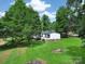 Single-story home on large lot surrounded by green trees and expansive grass at 10379 Turnplow Dr, Davidson, NC 28036