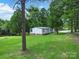 Single-story home on large lot surrounded by green trees and expansive grass at 10379 Turnplow Dr, Davidson, NC 28036
