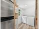 Bright laundry room with modern stainless refrigerator, utility sink, and appliances at 10379 Turnplow Dr, Davidson, NC 28036