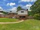 The home features a grassy backyard, complemented by a charming pathway and a covered porch area at 1040 Spring Dr, Gastonia, NC 28052