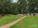 Large grassy backyard with pathway, shed, and fenced yard provides plenty of outdoor space at 1040 Spring Dr, Gastonia, NC 28052