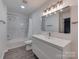 Bright bathroom featuring marble tile in shower, updated vanity and fixtures and vinyl flooring at 1040 Spring Dr, Gastonia, NC 28052
