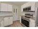 The kitchen features stainless steel appliances, white cabinets, and a stylish door at 1040 Spring Dr, Gastonia, NC 28052