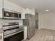 The kitchen is equipped with stainless steel appliances and modern white cabinets at 1040 Spring Dr, Gastonia, NC 28052