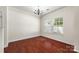 Bright, empty living room with hardwood floors and a chandelier, ready for personalization at 12009 Elizabeth Madison Ct, Charlotte, NC 28277