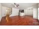 Bright living room features hardwood floors, a ceiling fan, and access to kitchen and stairway at 12009 Elizabeth Madison Ct, Charlotte, NC 28277