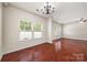 Spacious living room featuring hardwood floors, large windows, and ceiling fan at 12009 Elizabeth Madison Ct, Charlotte, NC 28277