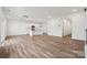 Spacious living room with wood-look floors, bright lighting, and an adjacent eat-in kitchen area at 1228 Hallman Branch Ln, Lincolnton, NC 28092
