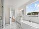 Bathroom with white marble floors, white cabinets, and a freestanding tub at 13618 Tranquil Day Dr, Matthews, NC 28105