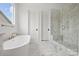 Bright bathroom with a free-standing tub and marble shower at 13618 Tranquil Day Dr, Matthews, NC 28105