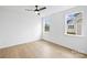 Well-lit bedroom with wood flooring and two windows at 13618 Tranquil Day Dr, Matthews, NC 28105