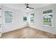 Bright bedroom featuring hardwood floors, multiple windows, and a ceiling fan at 13618 Tranquil Day Dr, Matthews, NC 28105