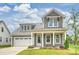 Charming two-story home with a welcoming front porch, manicured lawn, and an attached garage at 13618 Tranquil Day Dr, Matthews, NC 28105