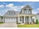 Charming gray two-story home with a welcoming front porch and attached two-car garage at 13618 Tranquil Day Dr, Matthews, NC 28105