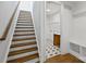 Staircase with wood treads and a laundry room with tiled floors at 13618 Tranquil Day Dr, Matthews, NC 28105