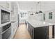 Spacious open kitchen featuring a large island with marble countertop, stainless appliances, and pendant lighting at 13618 Tranquil Day Dr, Matthews, NC 28105
