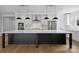Bright kitchen with stainless appliances, white cabinets, and large black island with marble countertop at 13618 Tranquil Day Dr, Matthews, NC 28105