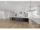 Bright kitchen with stainless appliances, white cabinets, and large black island with marble countertop at 13618 Tranquil Day Dr, Matthews, NC 28105