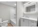 A modern white bathroom with a lighted mirror, a toilet, and a tub with shower at 1440 10Th Sw Ave, Hickory, NC 28602
