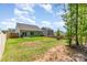 Large grassy backyard with a patio, new wooden fence, and young trees at 160 Tanner Loop, Troutman, NC 28166