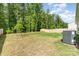 Backyard with a young tree, a wooden fence, and an air conditioning unit at 160 Tanner Loop, Troutman, NC 28166