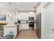 Well-lit kitchen features stainless appliances, white cabinets, granite counters, and eat-in island at 160 Tanner Loop, Troutman, NC 28166
