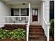 Inviting front porch with brick steps, white railings and space for outdoor seating at 165 Kimball Rd, China Grove, NC 28023