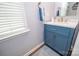 Charming powder room with a blue vanity, gold fixtures, and a stylish patterned floor at 17228 River Race Dr, Huntersville, NC 28078