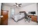 Comfortable bedroom with a decorative bed, ceiling fan, dresser, and a desk with computer, perfect for work and relaxation at 17228 River Race Dr, Huntersville, NC 28078