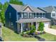 Charming two-story home featuring brick and blue siding, a covered porch, and well-landscaped yard at 17228 River Race Dr, Huntersville, NC 28078
