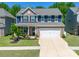 Beautiful two-story home with brick accents, blue siding, well-manicured lawn and a two-car garage at 17228 River Race Dr, Huntersville, NC 28078