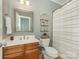 Charming bathroom featuring a wooden vanity, decorative mirror, and shower with striped curtain at 1814 Therrell Farms Rd, Waxhaw, NC 28173