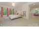 Bright bedroom with white walls, hardwood floors, pink curtains and decor, with shelving and hallway entrance at 1814 Therrell Farms Rd, Waxhaw, NC 28173