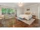 Inviting bedroom featuring hardwood floors, large windows, plush seating, and a comfortable bed at 1814 Therrell Farms Rd, Waxhaw, NC 28173