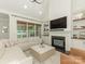 Bright and airy living room with a fireplace, built-in shelving, and large windows at 1814 Therrell Farms Rd, Waxhaw, NC 28173