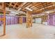 Unfinished basement with exposed ceiling, garage door and pink insulation ready for your customization at 18843 Flat Shoals Dr, Cornelius, NC 28031