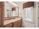 Bathroom with a granite countertop vanity, a large mirror, and a window, providing natural light at 18843 Flat Shoals Dr, Cornelius, NC 28031
