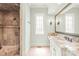 Bright bathroom showcasing granite counters, white cabinets, decorative wall sconces, and glass shower at 18843 Flat Shoals Dr, Cornelius, NC 28031