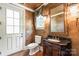 Elegant powder room featuring a dark wood vanity, decorative mirror, and ornate lighting fixture at 18843 Flat Shoals Dr, Cornelius, NC 28031
