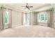 Spacious bedroom featuring large windows, neutral carpet, ceiling fan, and decorative crown molding at 18843 Flat Shoals Dr, Cornelius, NC 28031
