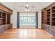 Home office featuring custom built-in bookshelves, hardwood floors, ample natural light, and a ceiling fan at 18843 Flat Shoals Dr, Cornelius, NC 28031