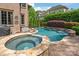 A luxurious spa and pool, featuring stone accents and a tranquil waterfall, perfect for relaxation and enjoyment at 18843 Flat Shoals Dr, Cornelius, NC 28031
