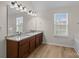 Primary bathroom with wood floors, dual sink vanity, granite countertop and large mirror at 2018 Rockycreek Ln, Monroe, NC 28112