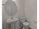 Bathroom featuring a pedestal sink, toilet and mirror, with neutral colors at 2018 Rockycreek Ln, Monroe, NC 28112