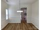 Bright dining room with modern chandelier, chair rail, and light, wood-look floors at 2018 Rockycreek Ln, Monroe, NC 28112