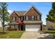 Charming two-story brick home with a well-manicured lawn, a two-car garage, and black shutters at 2018 Rockycreek Ln, Monroe, NC 28112