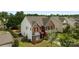 Aerial view showcasing the home's brick and vinyl facade, landscaping, and fenced yard at 2018 Rockycreek Ln, Monroe, NC 28112