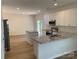 Well-lit kitchen features granite counters, stainless appliances, island, and view to the backyard at 2018 Rockycreek Ln, Monroe, NC 28112