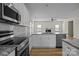 Open kitchen with white cabinets, granite countertops, stainless steel appliances, and hardwood floors at 2018 Rockycreek Ln, Monroe, NC 28112